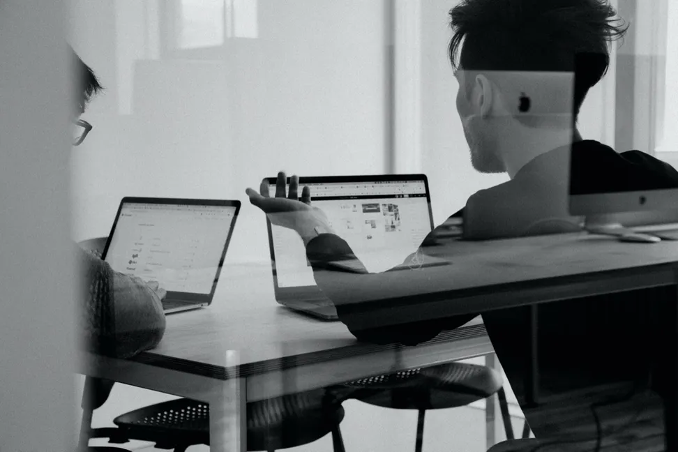 Team members collaborating at a shared desk